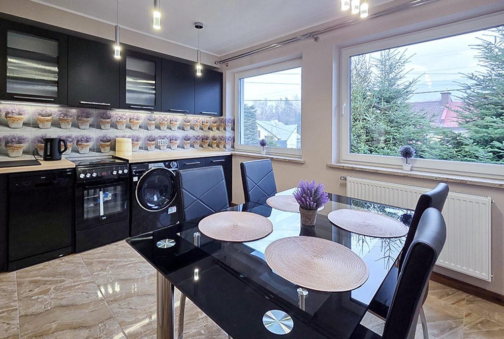 na pierwszym planie jadalnia, w oddali kuchnia w luksusowym apartamencie do wynajmu Bielsko-Biała okolice