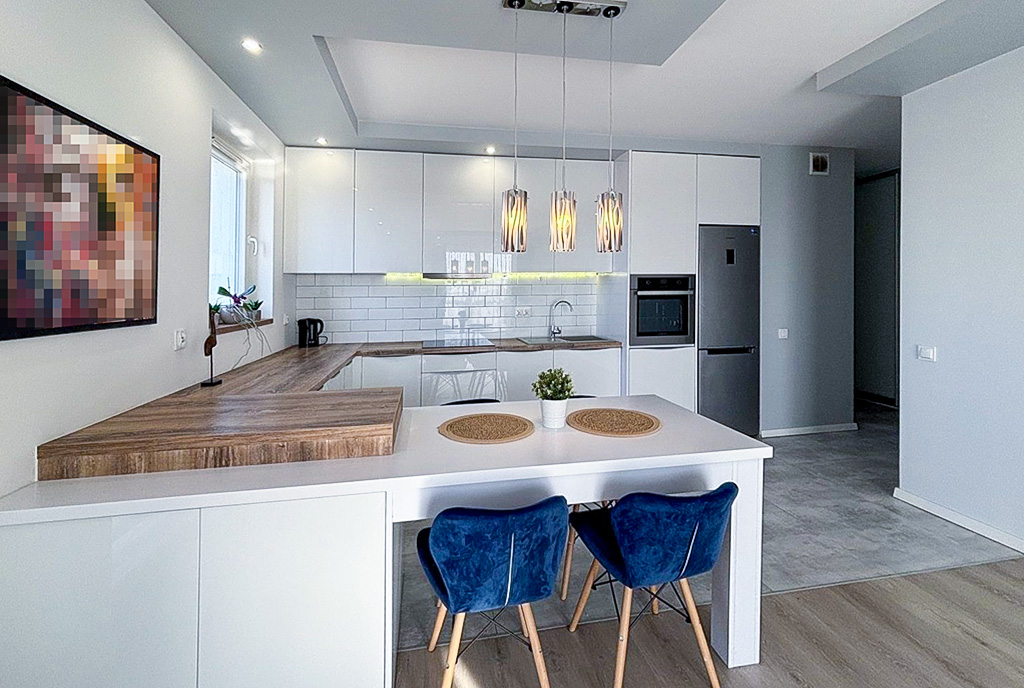 na pierwszym planie jadalnia, w oddali kuchnia w luksusowym apartamencie na sprzedaż Szczecin