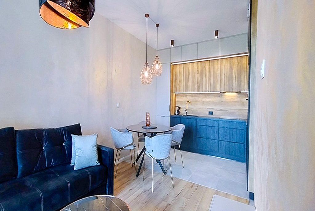 na pierwszym planie jadalnia, w oddali kuchnia w luksusowym apartamencie do wynajmu Legnica okolice