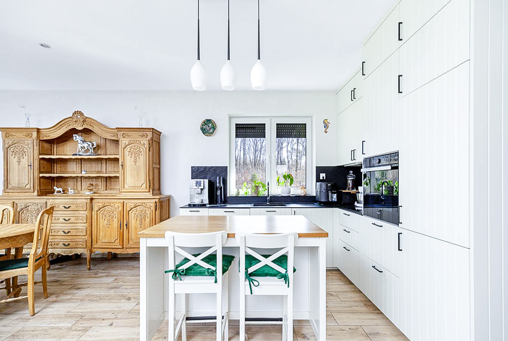 na pierwszym planie jadalnia, w oddali kuchnia w luksusowej willi na sprzedaż Poznań (okolice)