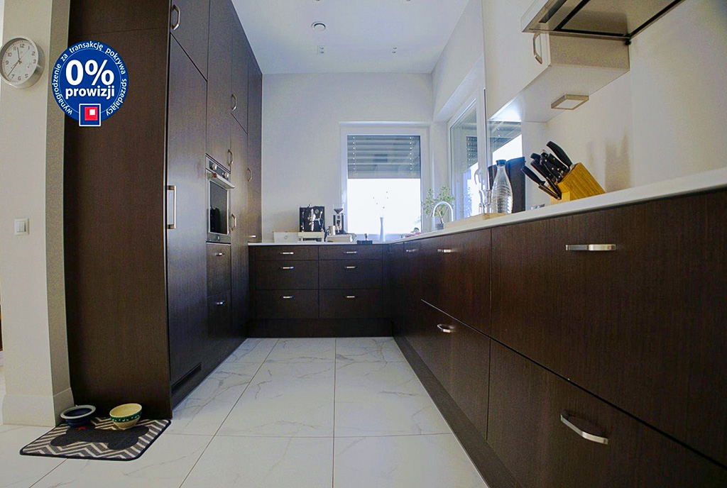zaaranżowane w ciemnym drewnie kuchnia w luksusowej willi na sprzedaż Warszawa okolice