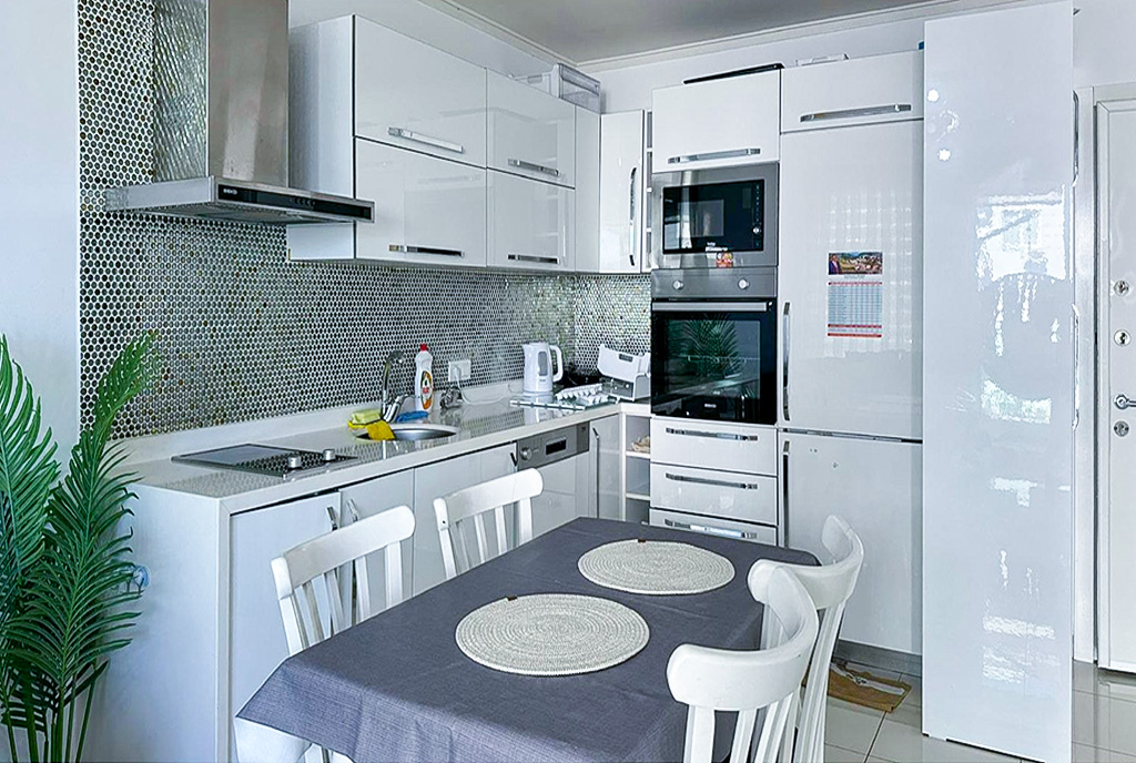 na pierwszym planie jadalnia, w oddali kuchnia w luksusowym apartamencie na sprzedaż Turcja Alanya