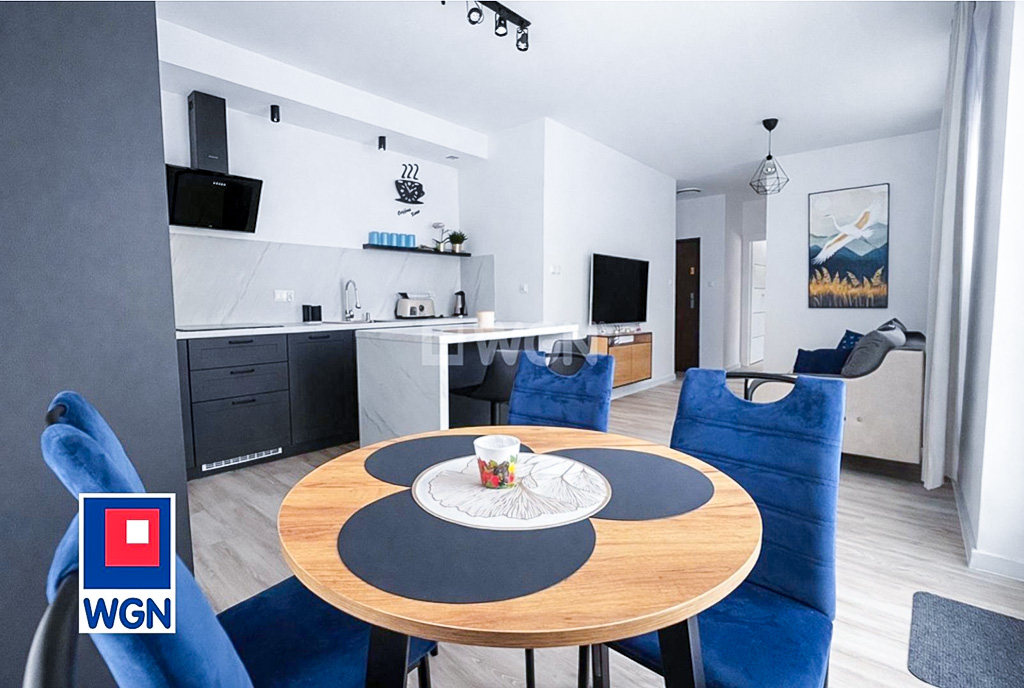 na pierwszym planie jadania, w oddali aneks kuchenny w ekskluzywnym apartamencie na wynajem Gdynia okolice