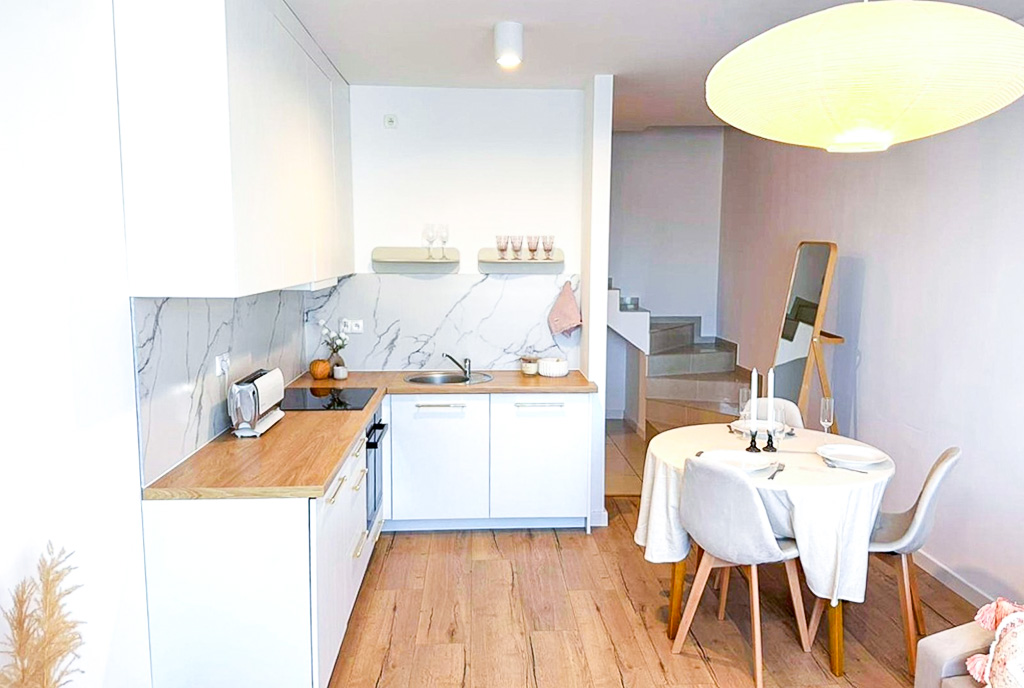 po lewej kuchnia, po prawej jadalnia w ekskluzywnym apartamencie na sprzedaż Gdynia okolice