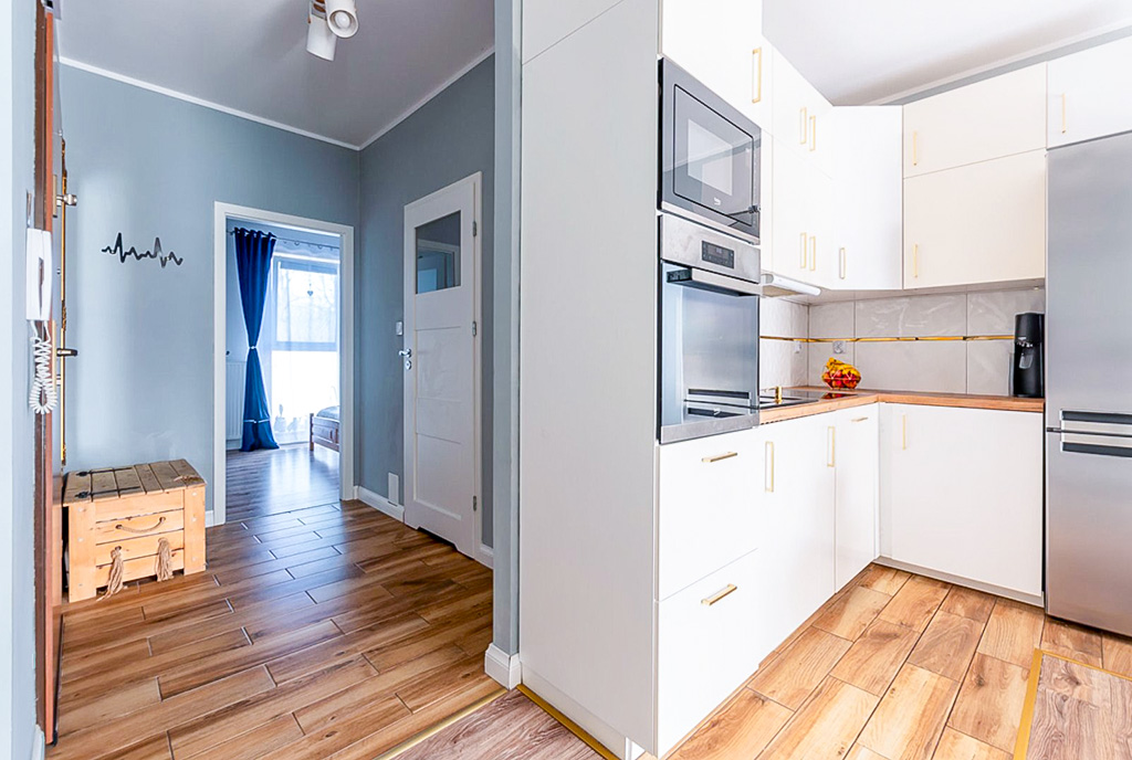 po lewej hol, po prawej kuchnia w luksusowym apartamencie na sprzedaż Elbląg