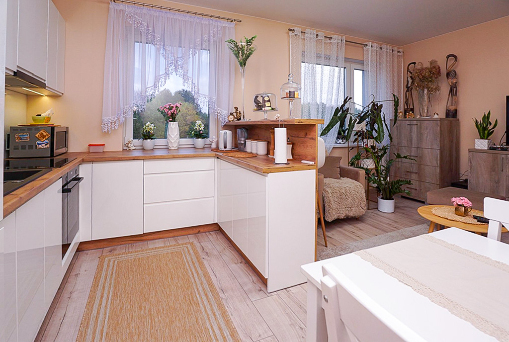 po lewej kuchnia, po prawej salon w luksusowym apartamencie na sprzedaż Piotrków Trybunalski