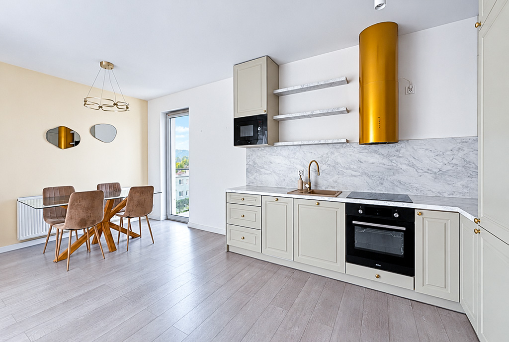 po lewej jadalnia, po prawej kuchnia w ekskluzywnym apartamencie na sprzedaż Gdynia (okolice)