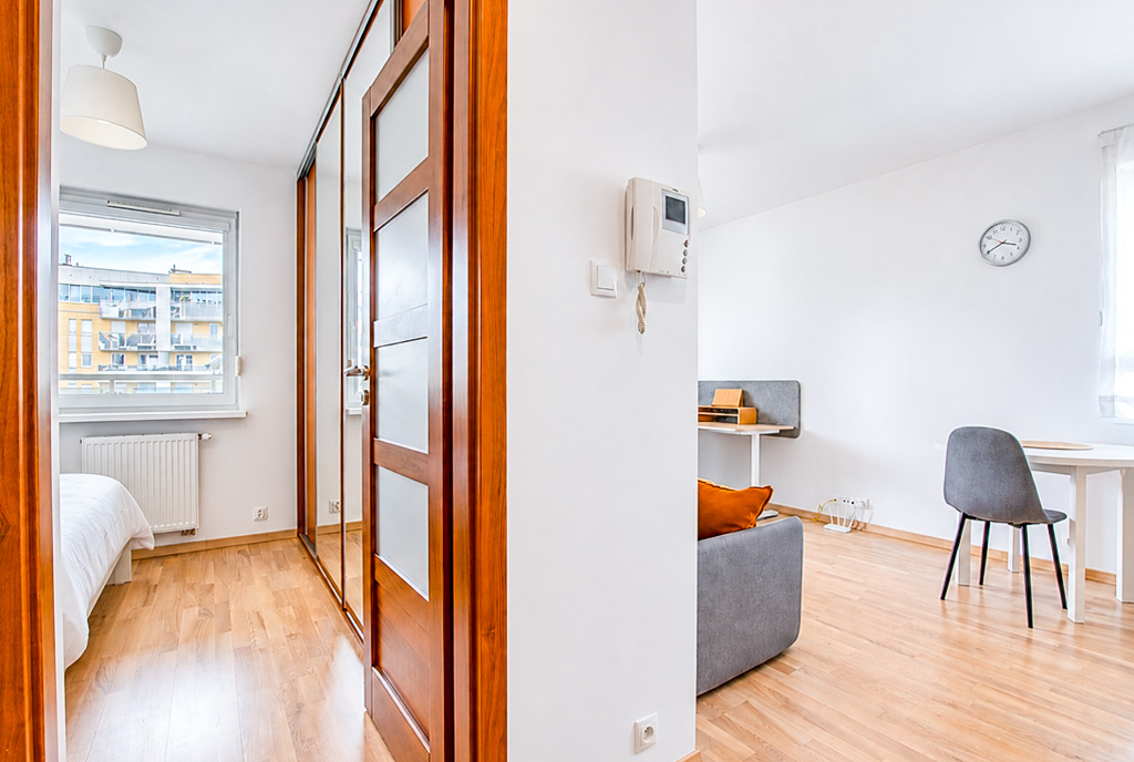 po lewej sypialnia, po prawej salon w ekskluzywnym apartamencie do wynajęcia Poznań